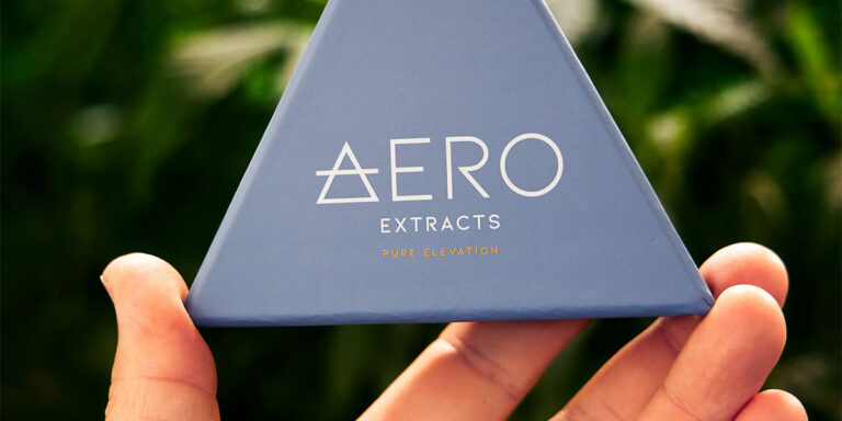 Hand holding an Aero Extracts box for recycling