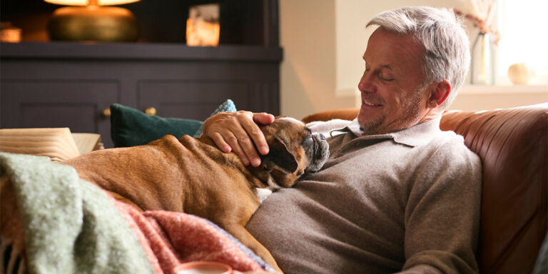 Man relaxing on couch with dog