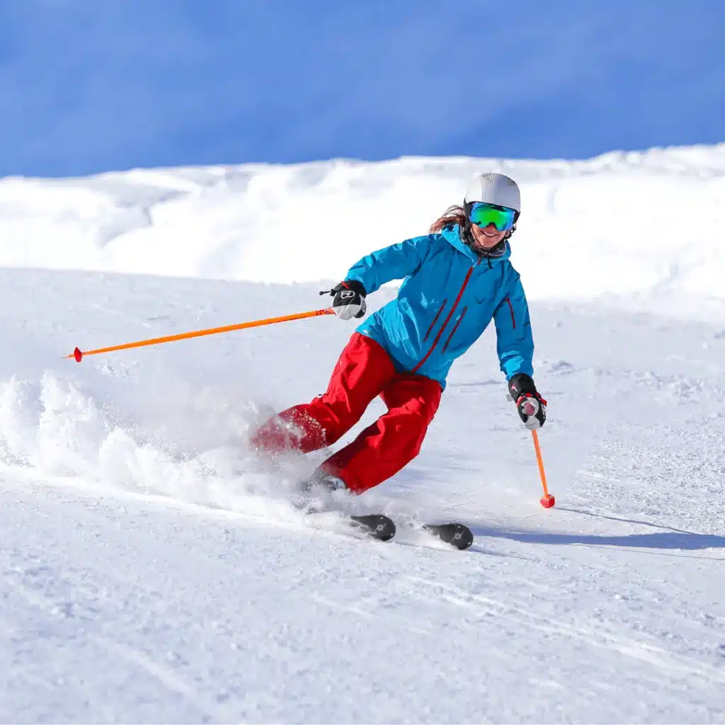Skier downhill skiing on a snowy mountain slope