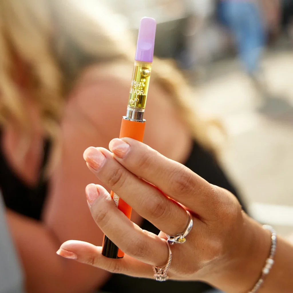 Person holding a compact 510 thread vape cart battery close-up