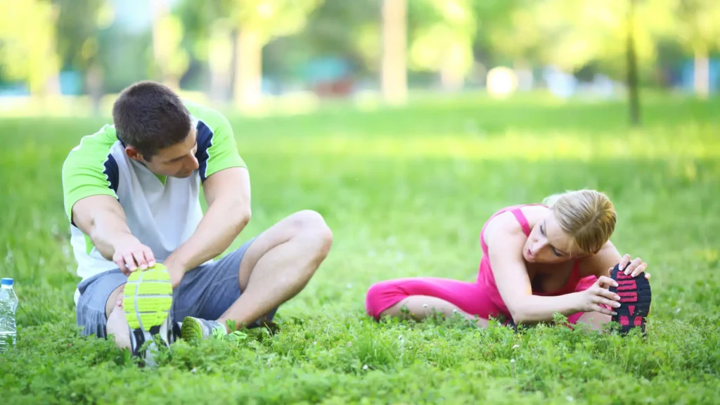 man and woman stretching in the grass