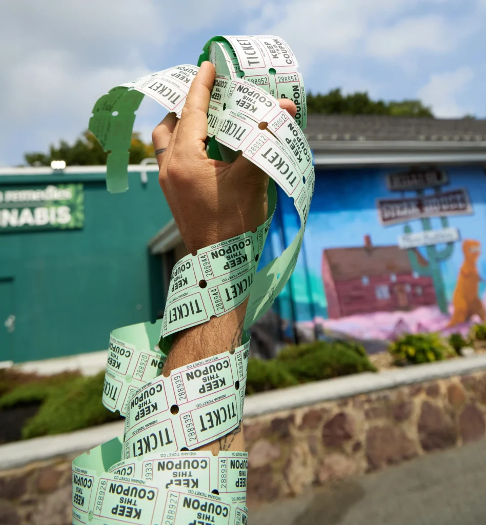 Arm covered in raffle tickets in front of Garden Remedies Melrose Cannabis Dispensary