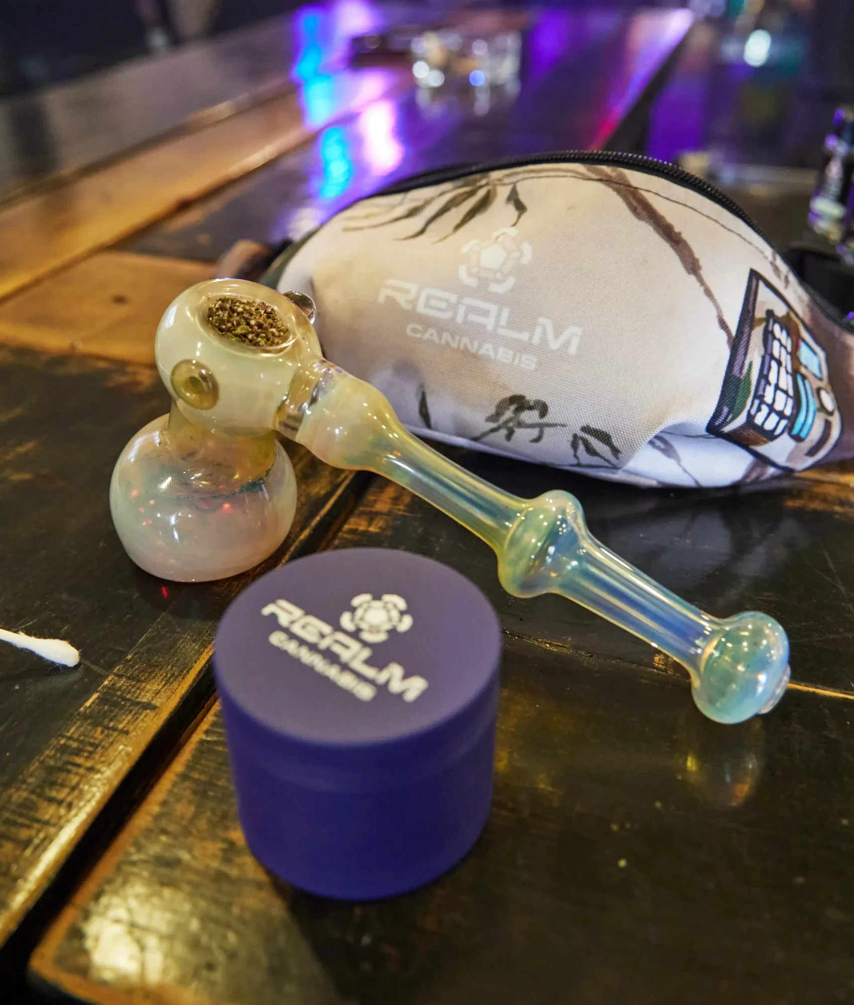 packed bowl, Realm fannypack, and Realm grinder on a tabletop