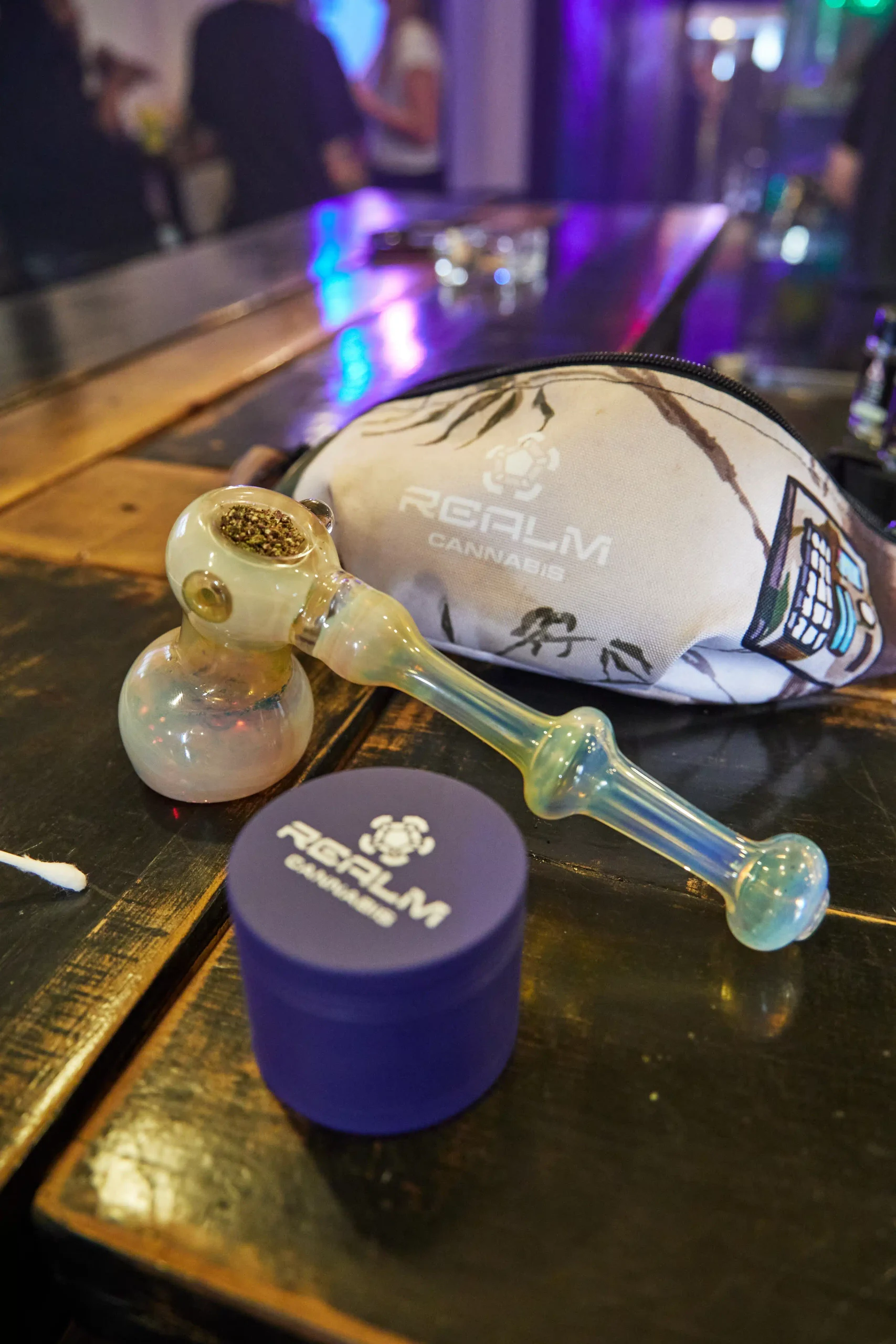 packed bowl, Realm fannypack, and Realm grinder on a tabletop